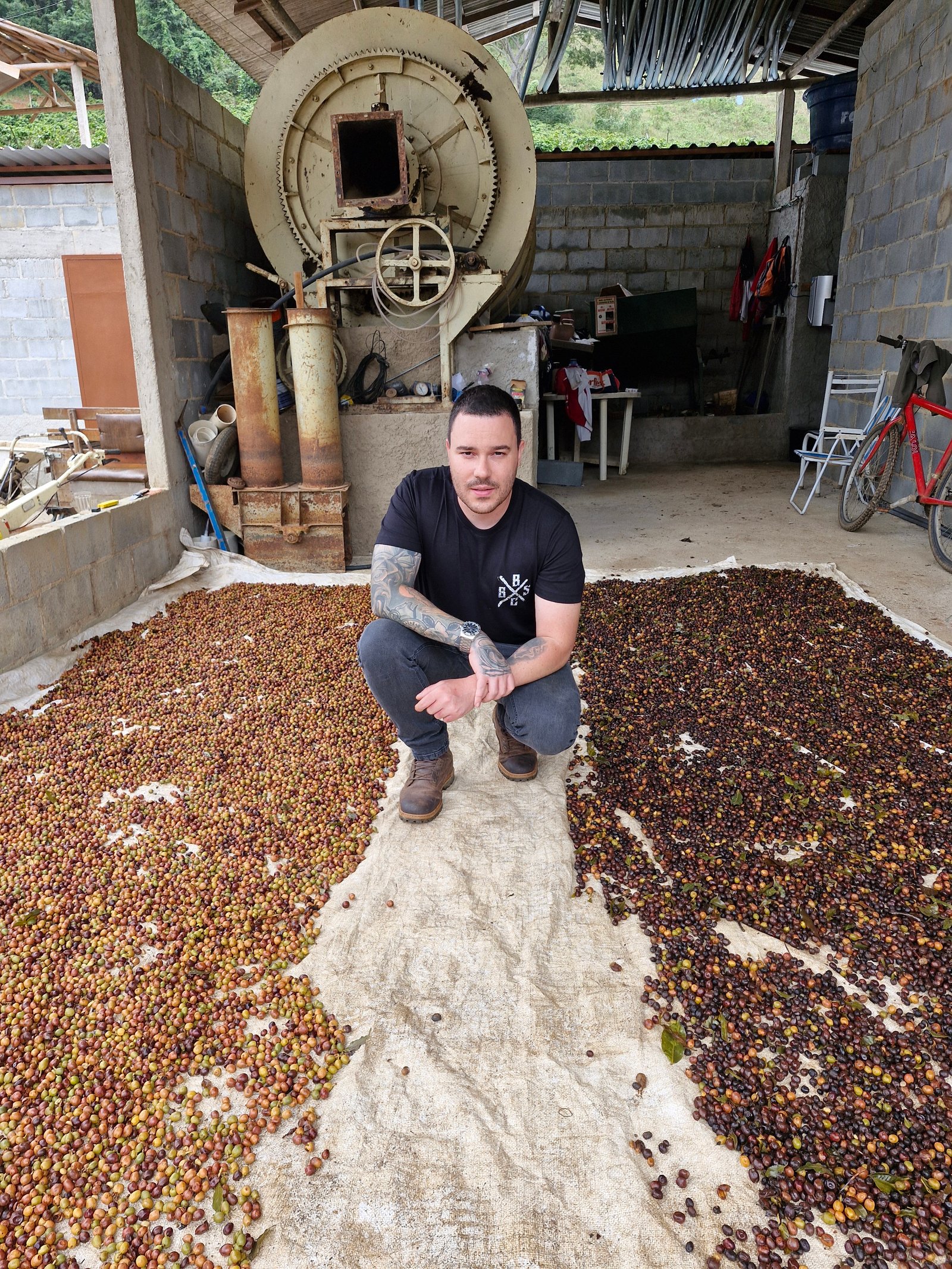 Thiago da Coffeeria no terreiro de secagem com cafés em processo natural